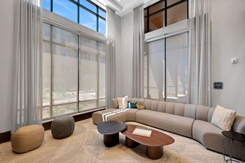 a living room with large windows and a couch and a table at Preston Ridge, Cary, 27513